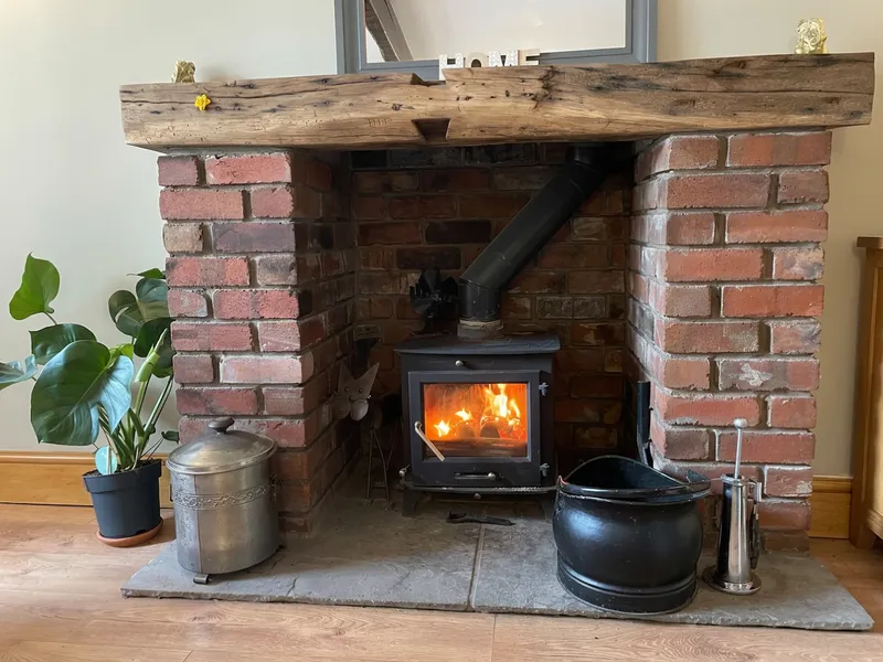The multi-fuel stove lit in the brick fireplace